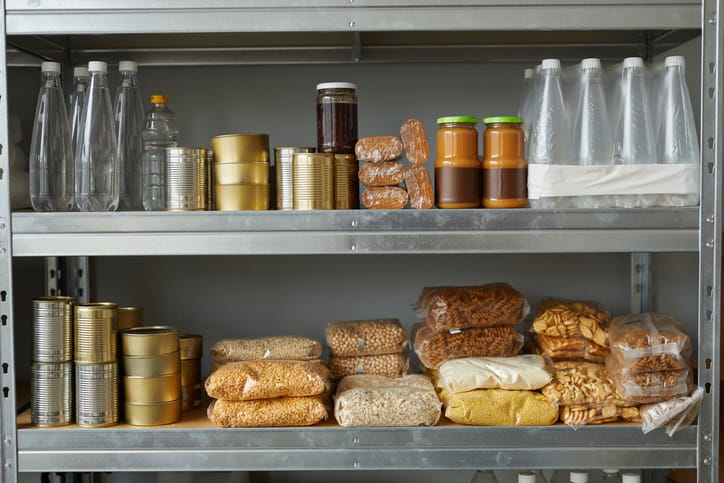 Non-perishable food items sitting on a metal shelving unit.