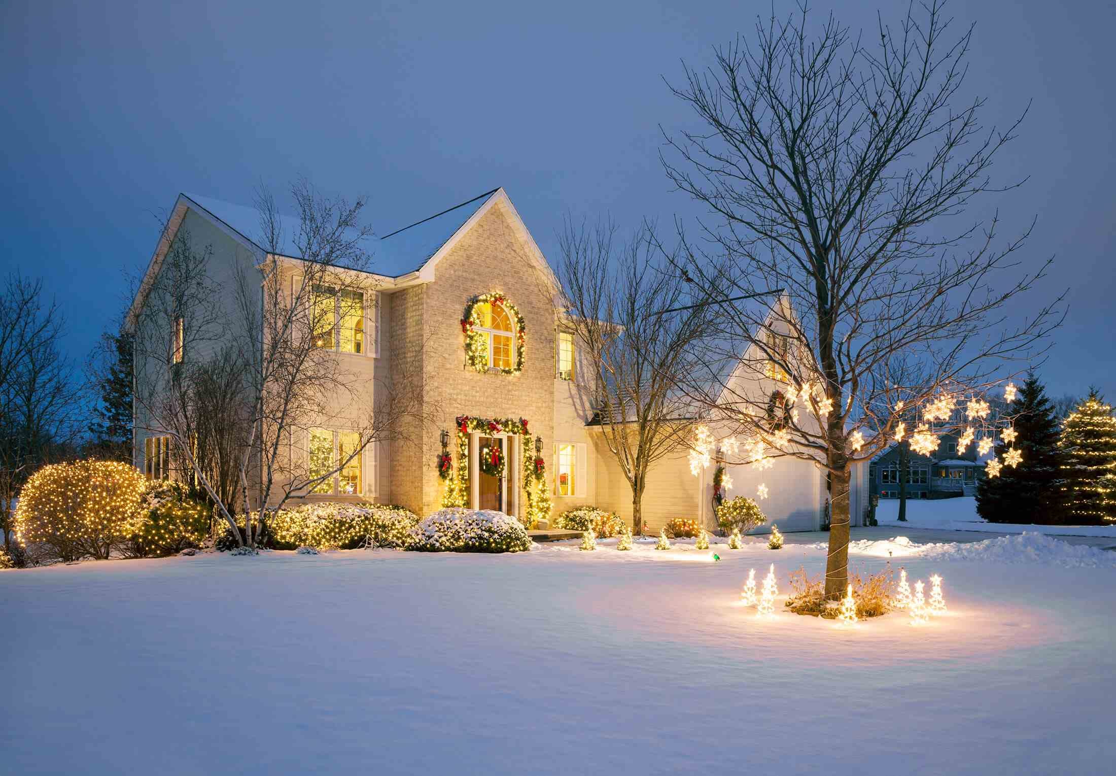 Winter luxury brick home at dusk with Christmas lights